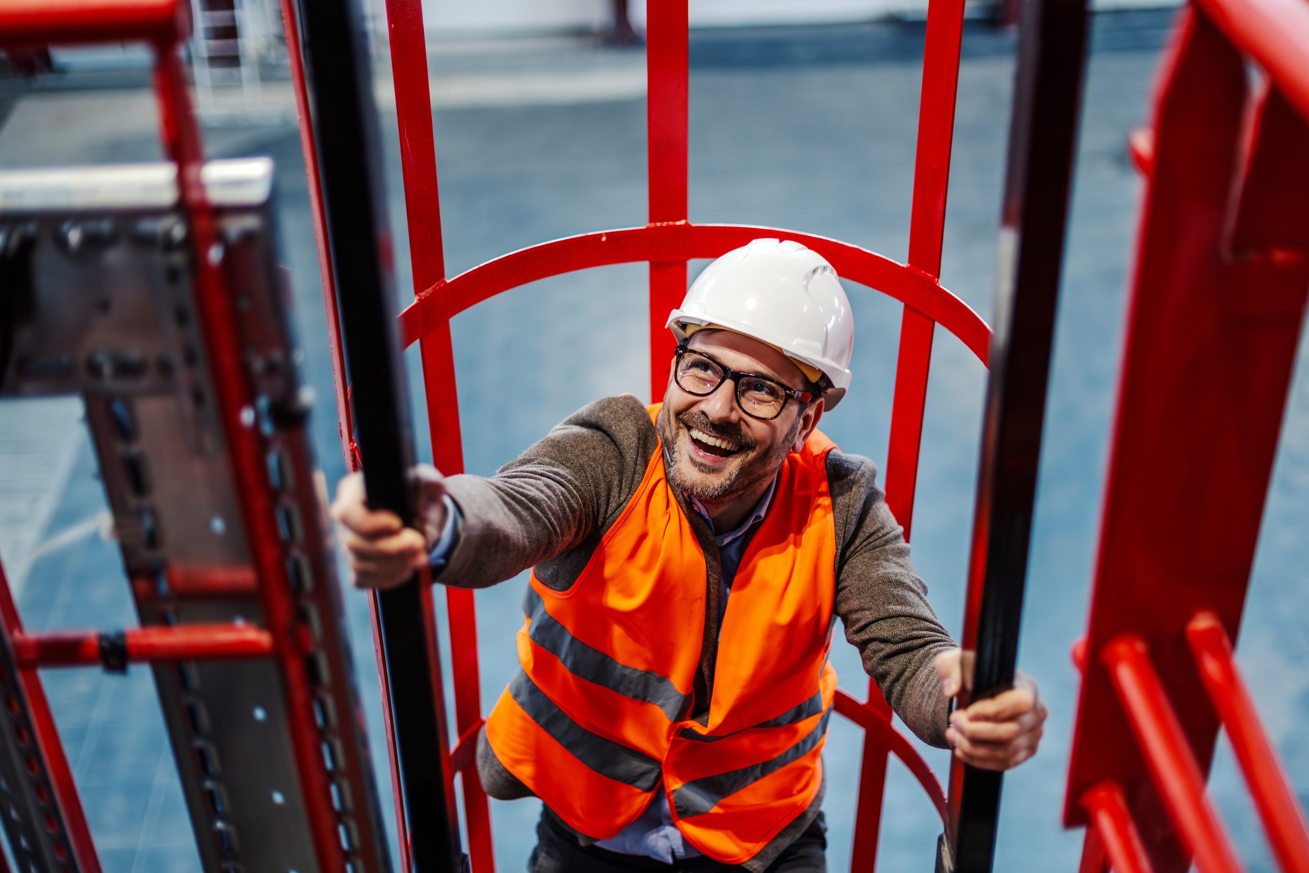 Worker climbing a caged ladder on site.